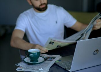 اخبار پڑھتے ہوئے خبر کی جانچ اور تصدیق کی علامتی تصویر